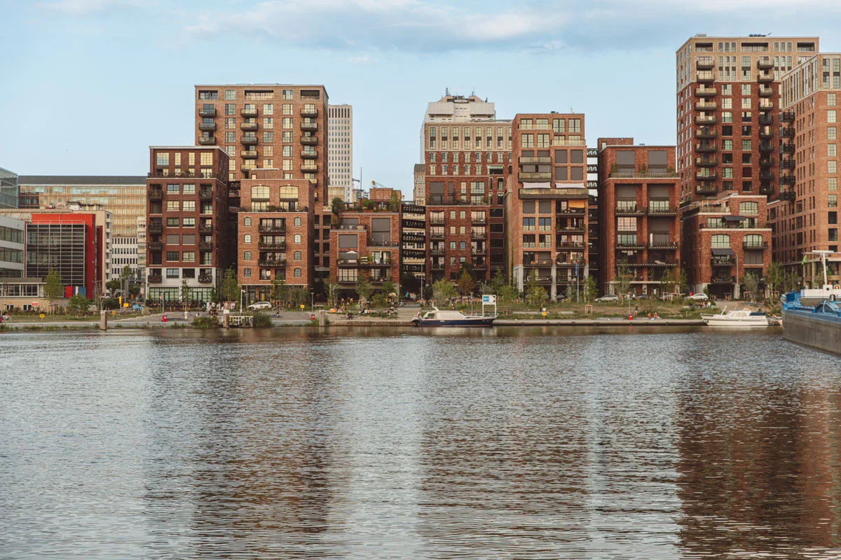Moderne woongebouwen aan de Karl Weisbardstraat weerspiegelen in het water van een stadsvaart.